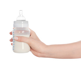 Fototapete - Female hand holding a baby bottle of milk on white background