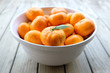 Imperfect satsuma mandarins - organic fruit produce - in a white bowl on a wooden background. Photographed with shallow depth of field in New Zealand.