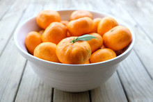 Imperfect Satsuma Mandarins - Organic Fruit Produce - In A White Bowl On A Wooden Background. Photographed With Shallow Depth Of Field In New Zealand.