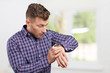 © fotofabrika - Handsome astonished young business man pointing on watch
