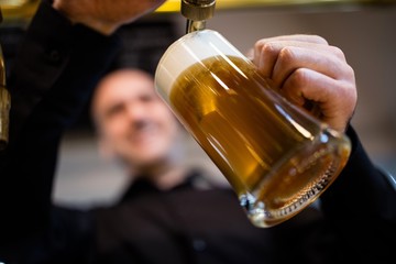 Wall Mural - Brewer filling beer in beer glass from beer pump