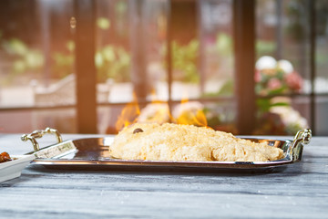 Wall Mural - Burning fish on tray. Whole breaded fish. Secret recipe for dorado fish. Breading made of sea salt.