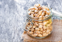 Pistachios  In The Glass Jar On Wooden Table