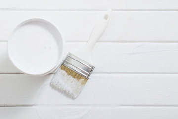 Bank paints and brush on a white wooden background