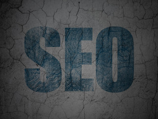 Web development concept: SEO on grunge wall background