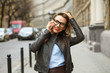 © vladstar - Businesswoman walking down the street while talking on smart pho