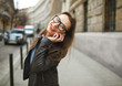 © vladstar - Businesswoman walking down the street while talking on smart pho