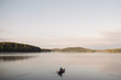 © Connect Images - Senior woman canoeing on lake, rear view