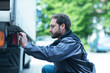 © Connect Images - Man adjusting truck control panel