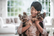 Happy Woman Hugging Pet Dogs At Home
