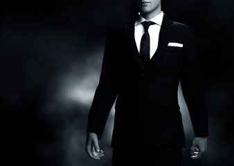 businessman, gentleman in elegant suit on black background. middle body view