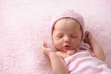 Newborn Baby Girl Wearing A Pink Knitted Bonnet