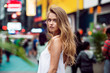© Nick Starichenko - Beautiful blonde sexy tourist girl walking in busy city street with long hair flying on the wind. Woman looking at camera outdoors wearing fashionable white t-shirt. New York City lifestyle photo.