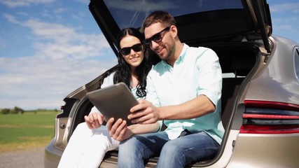 Poster - happy couple with tablet pc at hatchback car trunk 34