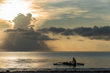 Fisherman In Traditional Boat At Sunrise