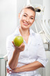© LazorPhotography - Portrait of beautiful female doctor in white uniform smiling and holding green fresh ripe apple. Face expressions, emotion, health care, medicine, occupation
