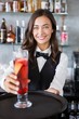 © WavebreakmediaMicro - Beautiful waitress holding tray with cocktail glass