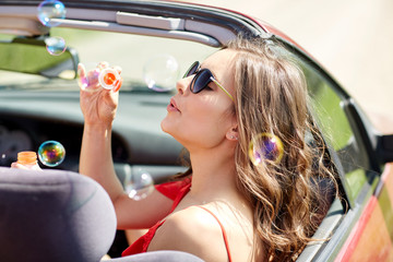 Wall Mural - woman blowing bubbles in convertible car