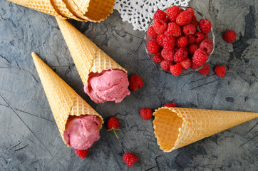 Poster - Raspberry ice cream with ice cream cones on stone table. Top view.
