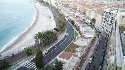 Poster - Along the promenade walk tourist and people who live in france. By seaside riding motorbikes on the road. On the seashore buildings historic architecture. Nice in spring season. French riviera