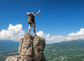 Wall Mural - tourist on the peak of high rocks. sport and active life concept.