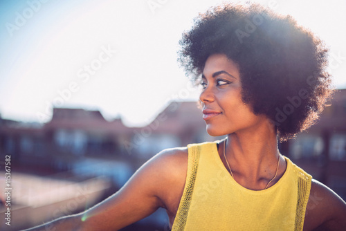 Láminas Beautiful African girl with curly hair on the rooftop