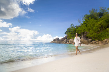 Wall Mural - a beautiful woman walking on the beach