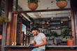 © Jacob Lund - Relaxed young man at cafe counter reading a book