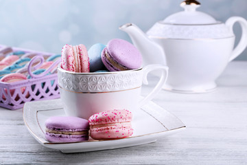 Wall Mural - Tasty macaroons with tea on wooden table