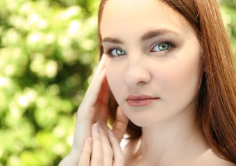 Wall Mural - Portrait of beautiful girl on blurred nature background