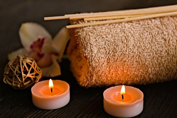 Poster - Beautiful spa composition with towel and lighted candle on dark table