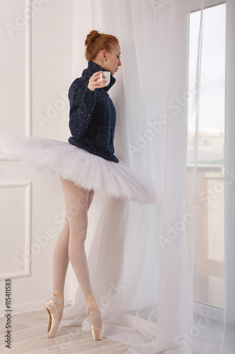 Obraz Dibond Ballerina drinking black tea at the window