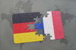 puzzle with the national flag of germany and france on a world map background.