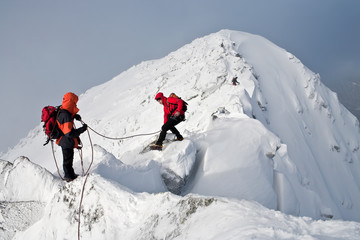 Climbing in mountains. Team work.