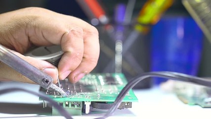 Poster - Close up shot soldering a circuit board with a soldering iron