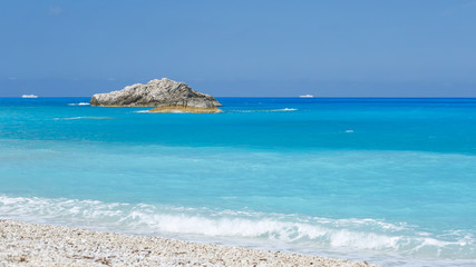 Beautiful sea and pebble beach with two cruise ship on horizon