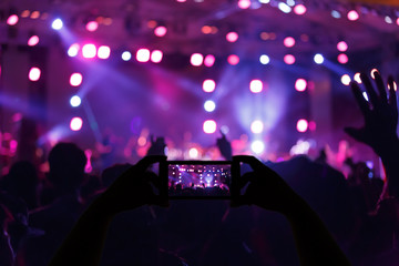 Take photo crowd in front of concert stage blurred