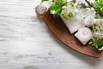 Spa treatment with blooming branch on white wooden table