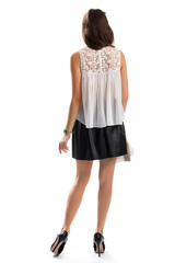 Wall Mural - Woman wears short skirt. Back view of white blouse. Trendy apparel from boutique. Small wrist watch.