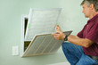 Professional repair service man or diy home owner a clean new air filter on a house air conditioner which is an important part of preventive maintenance.
