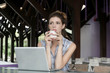 © triocean - Relaxed woman in front of her laptop holding a cup of coffee or tea