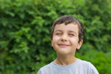 Portrait Of A Cute Smiling Boy With A Closed Eyes