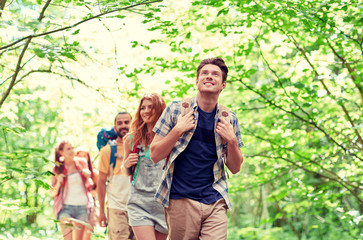 Canvas Print - group of smiling friends with backpacks hiking