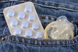 Tablette de pilules et préservatif masculin sortant de la poche d'un jean