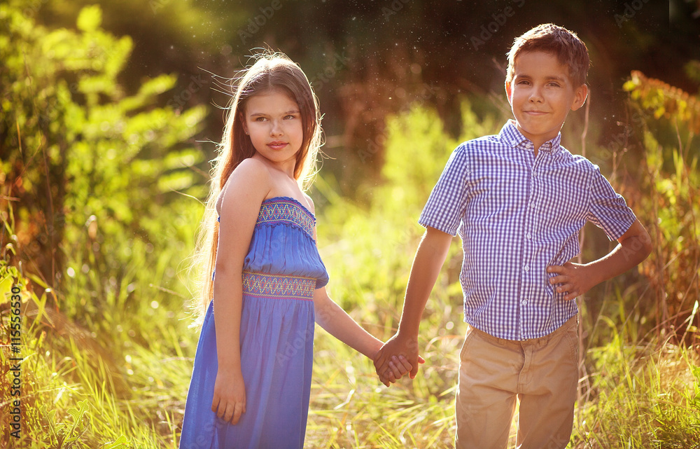 Beautiful little boy and girl holding hands at the park. Stock Photo ...