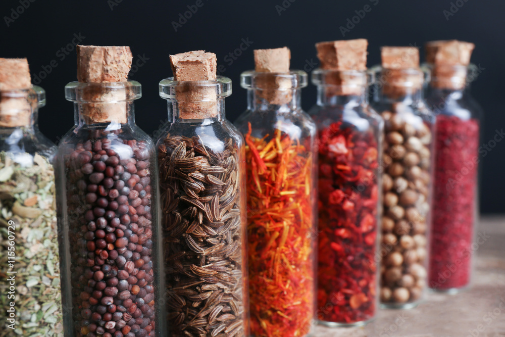 Different spices in small glass bottles, close-up