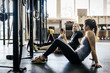 © FOLIO - Germany, Young women and men sitting on floor in gym