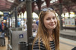 © FOLIO - Portrait of smiling young woman standing at subway station