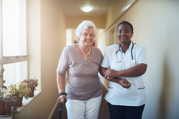 Wall Mural - Nurse assisting a senior patient to walk