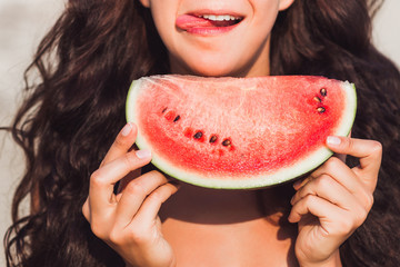 Girl eating a piece of watermelon with happy smile